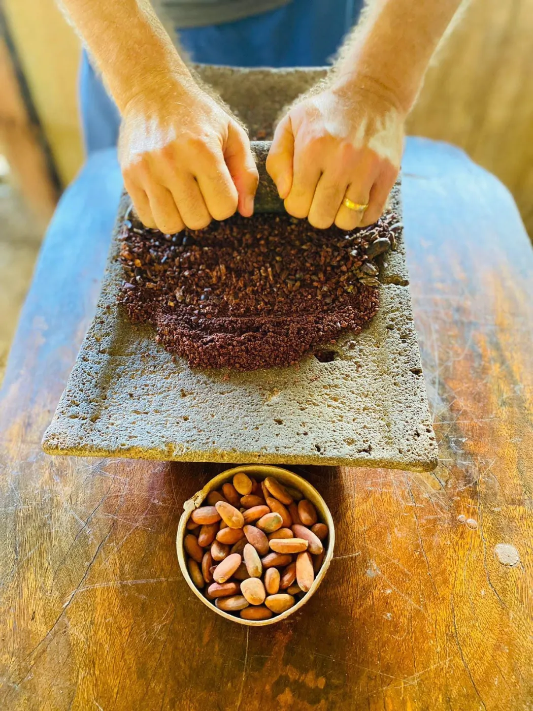 A guest taking part in grinding cacao by hand
