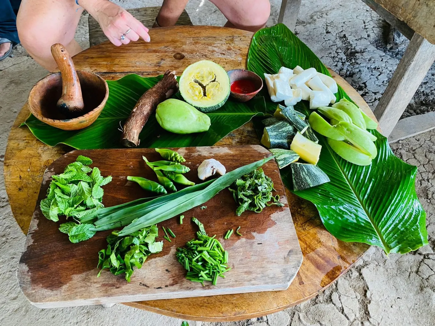 Fresh local vegetables and herbs arranged on banana leaves
